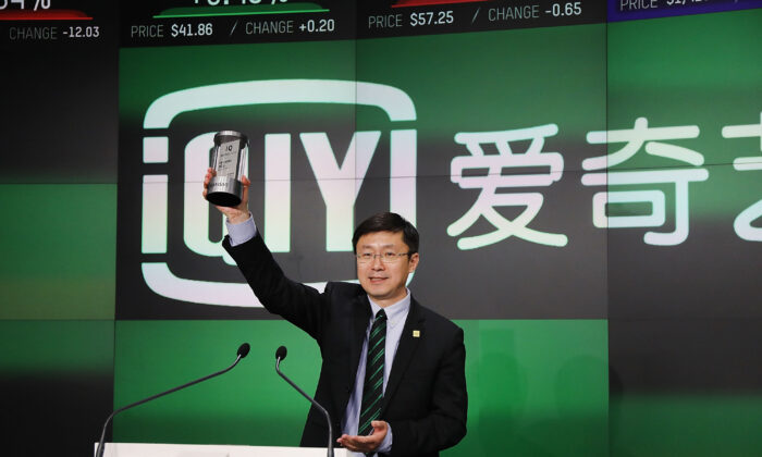 Основатель и генеральный директор компании iQiyi Юй Гун стоит на трибуне, прежде чем позвонить в колокол открытия на Nasdaq MarketSite на Таймс-сквер в честь своего первичного публичного размещения акций (IPO) в Нью-Йорке, 29 марта 2018 года