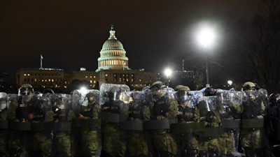 Процесс аккредитации был сорван в среду (6 января) после ожесточенной конфронтации в Конгрессе во время совместного заседания Конгресса США. Законодатели планируют возобновить сессию ближе к вечеру. На фото - сотрудники ОМОНа у здания Капитолия. (KEVIN DIETSCH/POOL/AFP)