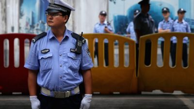 Китайские милиционеры охраняют вход в здание народного суда в Цзинане на четвёртый день судебного разбирательства в отношении бывшего члена Политбюро Бо Силая, 25 августа 2013 года, Китай. Фото: Feng Li/Getty Images