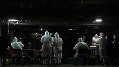 Жители проходят тесты на коронавирус в подвале жилого комплекса в рамках программы массового тестирования после появления новых случаев заражения вирусом в Шицзячжуане, в провинции Хэбэй в центральном Китае, 12 января 2021 года. STR/AFP via Getty Images