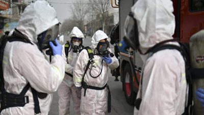 Люди в защитных костюмах готовятся распылить дезинфицирующее средство на улице в районе Гаочэн, который был объявлен зоной высокого риска в Шицзячжуане, в провинции Хэбэй на севере Китая, 15 января 2021 года. STR/CNS/AFP via Getty Images