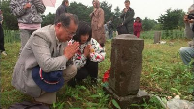 Японская семья посетила могилу своих родственников на острове Кунашире (Южные Курилы). Фото: JUNJI KUROKAWA/AFP/Getty Images
