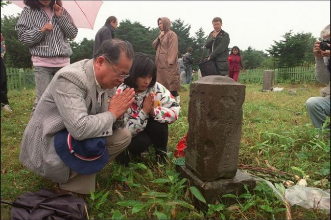 Японская семья посетила могилу своих родственников на острове Кунашире (Южные Курилы). Фото: JUNJI KUROKAWA/AFP/Getty Images