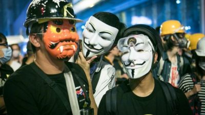 Протестующие в масках Гая Фокса стоят на передовой линии во время противостояния с полицией в Монгкоке, Гонконг, 5 ноября 2014 года. Фото: Benjamin Chasteen/Epoch Times