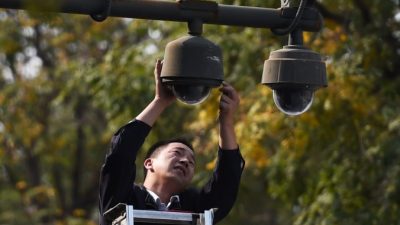 Рабочий настраивает камеры наблюдения на площади Тяньаньмэнь в Пекине 30 сентября 2014 года. Фото: GREG BAKER/AFP/Getty Images