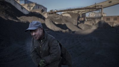 Китайский рабочий несёт уголь с шахты в Шаньси, 25 ноября 2015 г. Фото: Kevin Frayer/Getty Images