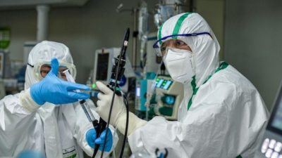 Врач лечит пациента, зараженного коронавирусом COVID-19, в больнице города Ухань в центральной китайской провинции Хубэй, 24 февраля 2020г. STR/AFP через Getty Images