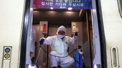 Работник в защитном костюме распыляет антисептическое средство в поезде на фоне опасений по поводу распространения нового коронавируса 2019 года, также известного как уханьская пневмония, Сеул, Южная Корея, 24 января 2020 года. Chung Sung-Jun/Getty Images