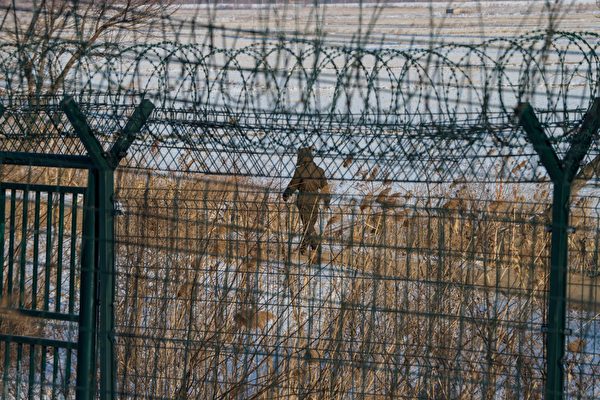 Северокорейский солдат идет вдоль пограничного забора северокорейского города Синыйджу напротив китайского пограничного города Даньдун в северо-восточной провинции Китая Ляонин, 10 января 2018 года. CHANDAN KHANNA/AFP/Getty Images