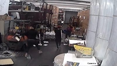 Двое злоумышленников, одетых в чёрное, с молотками в руках, запечатлены камерой видеонаблюдения в типографии, печатающей гонконгский выпуск The Epoch Times. 12 апреля 2021 года, The Epoch Times
