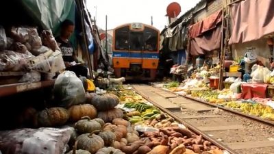 Рынок называется Maeklong Railway Market, так как рядом находится железнодорожная станция Маеклонг.  Скриншот с youtube.com