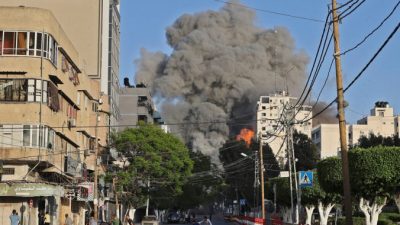 Люди убегают подальше от башни Аль-Шарук, когда она обрушилась 12 мая в городе Газа. Mohammed Abed/AFP via Getty Images