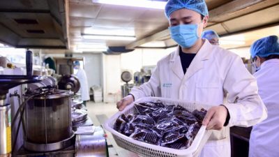 Медицинский работник держит препараты с лекарствами традиционной китайской медицины в больнице в Шэньяне, Китай, 20 февраля 2020 года. (STR/AFP via Getty Images)