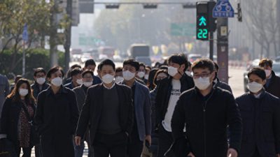 Пешеходы в масках переходят улицу в Сеуле 26 ноября 2020 года. ED JONES/AFP via Getty Images