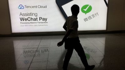 Мужчина проходит мимо рекламы – платформы WeChat для социальных сетей, принадлежащей китайской компании Tencent, в международном аэропорту Гонконга 21 августа 2017 г. (Ричард А. Брукс / AFP / Getty Images)
