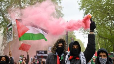 Пропалестинские демонстранты держат плакаты на марше в центре Лондона 22 мая 2021 г. Justin Tallis/AFP via Getty Images