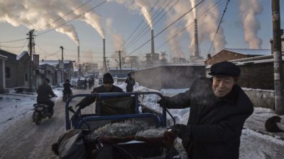 Дым из труб загрязняет воздух. Китайцы тянут тележку в районе угольной электростанции в Шаньси, Китай, 26 ноября 2015 года. (Kevin Frayer/Getty Images)