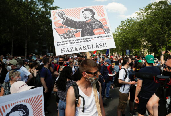 Демонстрант держит плакат с надписью «Измена» во время акции протеста против строительства кампуса Китайского университета Фудань в Будапеште, Венгрия, 5 июня 2021 г.