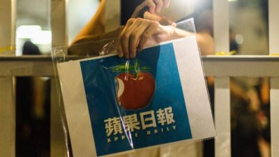 Сторонник держит плакат с логотипом газеты Apple Daily возле офисного здания медиакомпании в Гонконге рано утром 24 июня 2021 г. Anthony Wallace/AFP via Getty Images