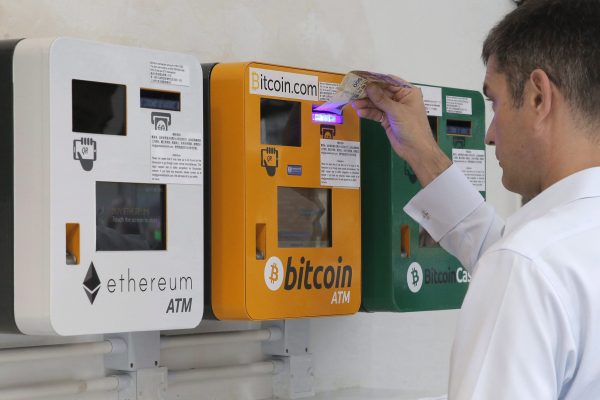 Мужчина использует банкомат с биткоинами в Гонконге 11 мая 2018 г.