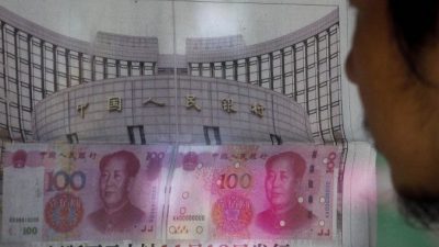 Мужчина читает газетное сообщение о том, что центральный банк Китая объявил о девальвации жестко контролируемой валюты Китая 11 августа 2015 года после спада в торговле, что спровоцировало крупнейшее однодневное падение юаня за десятилетие. (AP Photo / Энди Вонг)