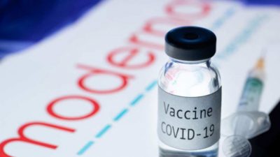 На снимке изображены шприц и флакон с надписью «Вакцина Covid-19» рядом с логотипом биотехнологической компании Moderna, 18 ноября 2020 года. JOEL SAGET/AFP via Getty Images