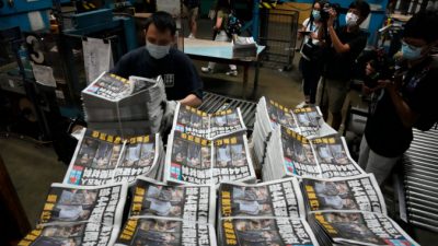 Рабочий упаковывает экземпляры газеты Apple Daily в типографии в Гонконге 18 июня 2021 года. AP Photo/Kin Cheung
