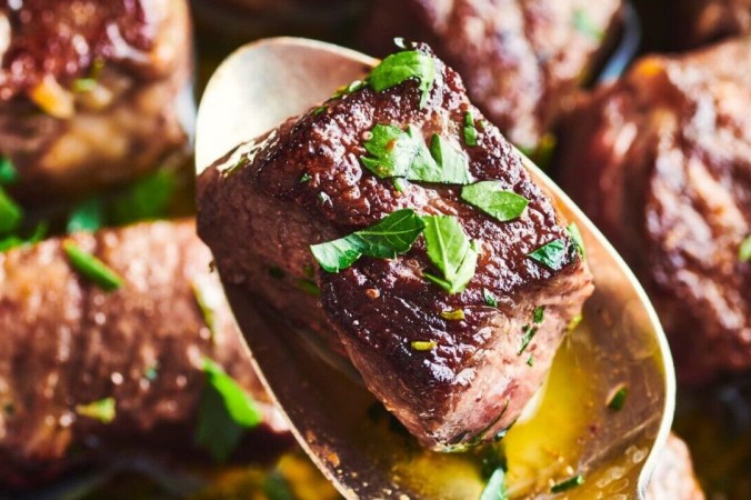 Кусочки стейка с пряным маслом Эти нежные кусочки стейка поливают свежим маслом с пряностями непосредственно перед подачей на стол. (Джо Лингеман / TNS)