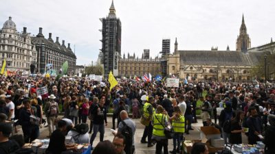 Демонстранты держат плакаты перед сбором на митинг «Вместе за свободу» против карантина и паспортов вакцинации на Парламентской площади в центре Лондона 29 мая 2021 г. Фото: Ben Stansall/AFP via Getty Images