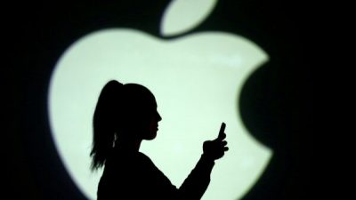 Силуэт мобильного пользователя на фоне логотипа Apple, 28 марта 2018 г. Dado Ruvic / Illustration / Reuters