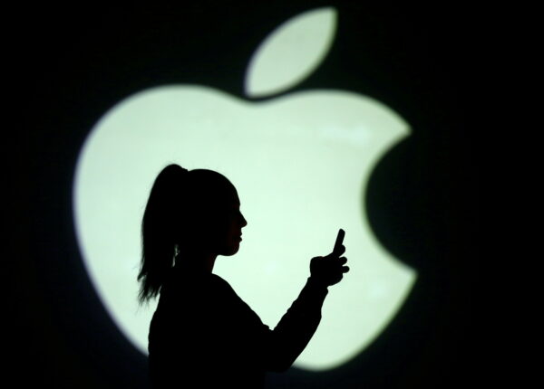 Силуэт мобильного пользователя на фоне логотипа Apple, 28 марта 2018 г. Dado Ruvic / Illustration / Reuters