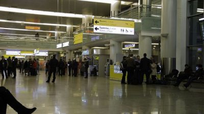 Пассажиры в терминале российского аэропорта Шереметьево под информационными указателями вылета и инфраструктуры.