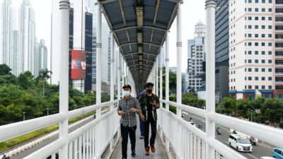 Люди в защитных масках идут по мосту в Джакарте, Индонезия, 17 июня 2021 г. (Ajeng Dinar Ulfiana / Reuters)
