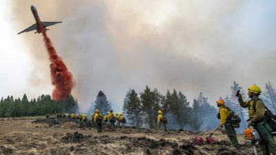 Самолёт сбрасывает огнезащитный состав на Харлоу-Ридж к юго-западу от Асотина, штат Вашингтон, 12 июля 2021 г. (Pete Caster / Lewiston Tribune через AP)