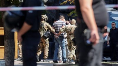 Сотрудники правоохранительных органов задерживают человека, который, по словам главы Национальной полиции, ворвался в главное правительственное здание Украины и угрожал взорвать гранату. Киев, Украина, 4 августа 2021 г. Serhii Nuzhnenko/Reuters