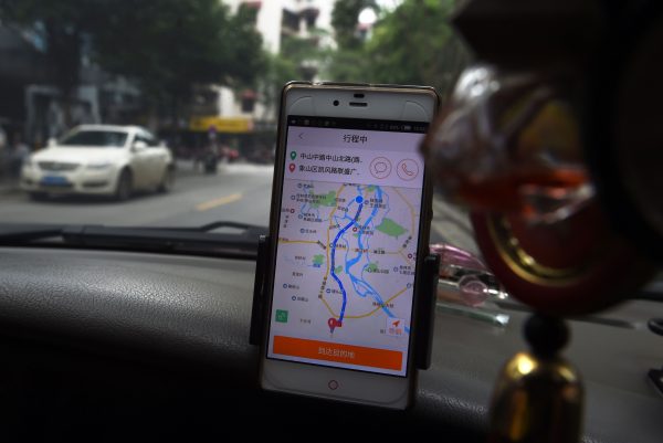 Водитель такси использует приложение Didi Chuxing, проезжая по улице города Гуйлинь в южной китайской провинции Гуанси 13 мая 2016 г. 