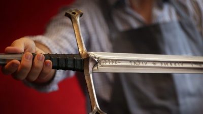Сотрудник Bonhams держит меч, принадлежащий Арагорну, герою трилогии «Властелин колец», в Лондоне, Англия, 31 июля 2014 г. Peter Macdiarmid/Getty Images