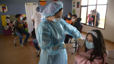 Подросток получает дозу вакцины Pfizer-BioNTech от COVID-19 в Фонде Сесилии Риваденейра в Кито 21 июля 2021 г.