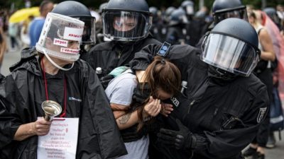 Полиция арестовывает протестующую девушку во время демонстрации против мер по борьбе с COVID-19 у Колонны Победы в Берлине 1 августа 2021 г. Fabian Sommer / dpa via AP
