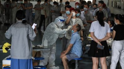 Рабочий проходит тест на COVID-19 на заводе по производству автомобильных запчастей в Ухане, провинция Хубэй в центральном Китае, 4 августа 2021 г. (STR/AFP via Getty Images)