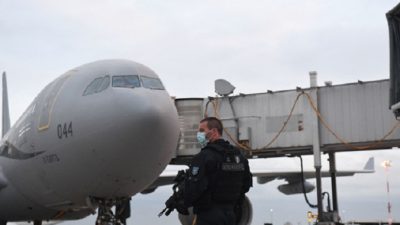 Французский жандарм охраняет стоянку самолёта Airbus A330 французской военной авиации после приземления с пассажирами из Афганистана в аэропорт Руасси им. Шарля Де Голля 18 августа 2021 года. Photo par Alain JOCARD / AFP via Getty Images.