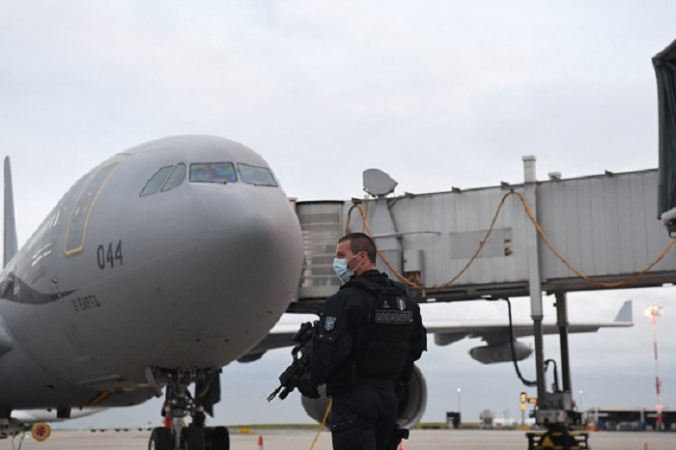 Французский жандарм охраняет стоянку самолёта Airbus A330 французской военной авиации после приземления с пассажирами из Афганистана в аэропорт Руасси им. Шарля Де Голля 18 августа 2021 года. Photo par Alain JOCARD / AFP via Getty Images.