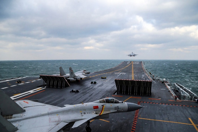Китайские истребители J-15 запускаются с палубы авианосца Liaoning во время военных учений в Желтом море у восточного побережья Китая 23 декабря 2016 г. (STR/AFP via Getty Images)