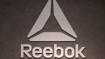 Логотип компании по производству обуви и одежды Reebok, дочерней компании немецкого гиганта спортивных товаров Adidas, можно увидеть в магазине в Мюнхене, на юге Германии, 10 марта 2021 г. (Christof Stache / AFP via Getty Images)