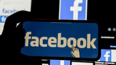 Логотип Facebook отрожается на мобильном телефоне на иллюстрации, сделанной 2 декабря 2019 г. (Johanna Geron / Illustration / Reuters)