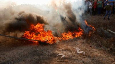 Протестующие подожгли покрышку возле забора на границе сектора Газа с Израилем во время акции протеста 21 августа 2021 г. (Adel Hana/AP Photo)