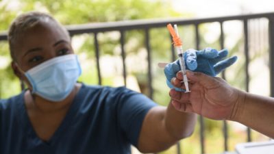 Медсестра получает дозу вакцины Pfizer, чтобы ввести её студенту в мобильной клинике вакцинации Covid-19 города Лонг Бич в Калифорнийском университете Лонг Бич (CSULB) в Калифорнии, 11 августа 2021 года (Patrick T. Fallon/AFP via Getty Images).