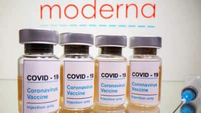 Флаконы с наклейкой «COVID-19 / вакцина против коронавируса / только для инъекций» и шприц видны перед логотипом Moderna на этой иллюстрации, сделанной 31 октября 2020 г.