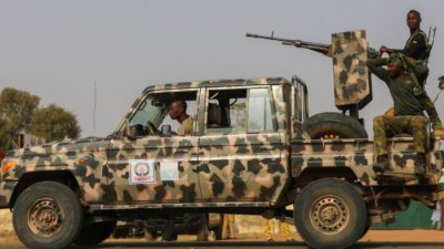 Силы безопасности патрулируют местность, пока люди ждут прибытия спасённых школьниц в Джангебе, Замфара, Нигерия, 3 марта 2021 года.