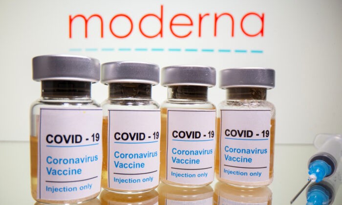 Флаконы с наклейкой «COVID-19 / вакцина против коронавируса / только для инъекций» и шприц видны перед логотипом Moderna на этой иллюстрации, сделанной 31 октября 2020 г.